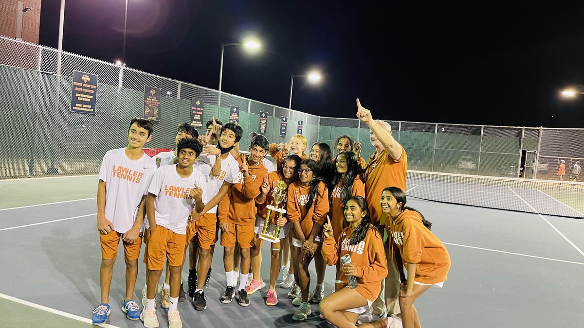 Aahana and the Lawler Tennis team celebrating a championship win with a trophy